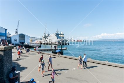 Summer day people enjoying Wellington waterfront strolling along the esplanade watching and relaxing in warm coastal public space.  February 2016