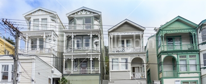 Traditional residential suburb above-ground power lines form an historical look to street comprised rows multi-story Victorian architectural style homes Wellington architecture Tinakori.