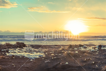Reto effect image at sunset Castlecliff Beach Wanganui sunset on wild windy day with windblown foam on black sand beach