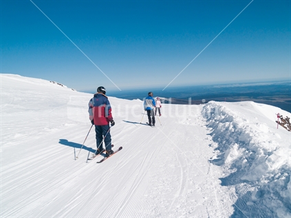 Three skiers on track around ski field