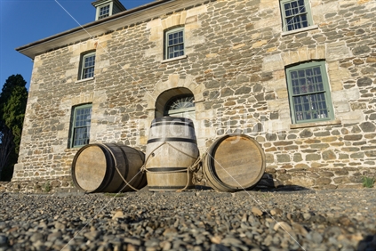 Three barrels in front historic Stone Store in morning light Kerikeri New Zealand.