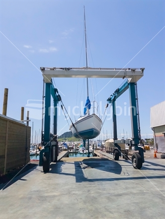 Tauranga Marina hardstand travel lift with yacht hoisted for maintenance