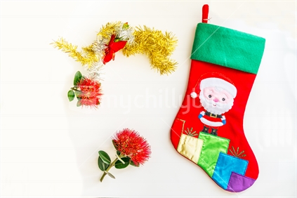 Child's santa stocking with rd pohutukawa flower and tinsel simple flat design on white.
