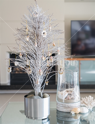Simple summer  Christmas small white tree on glass table with seaside vase decoration in lounge.