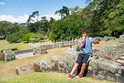 Boy taking selfie while licking and enjoying ice cream outdoors on summer day