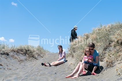 Four women, three generations in dunes on Muriwai Beach