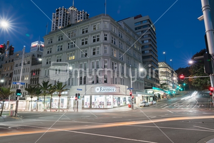 AUCKLAND, NEW ZEALAND - MARCH 25, 2018; Night scene corner Queen and Victoria Streets passing traffic and people in long exposure with department store Farmers illuminated across road.