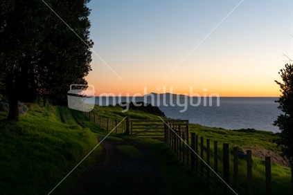 Ocean sunrise with Mayor Island on horizon viewed from lower slopes of Mount Maunganui, Tauranga