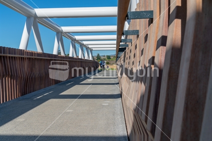TAURANGA, NEW ZEALAND - AUGUST 12 2018; Shadows create leading lines along architectural timber sides of white steel Takatimu Drive Overbridge is elevated pedestrial and cycle bridge crossing the highway below