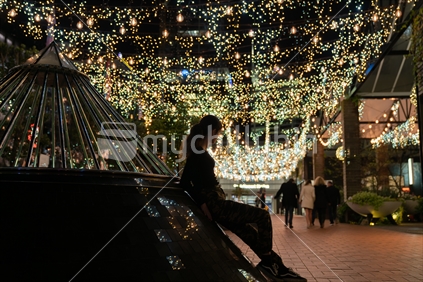 AUCKLAND, NEW ZEALAND - SEPTEMBER 14 2018; Silhouettes and blurry people moving about  in urban background image in Auckland's Britomart area bright and decorative lights at night