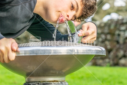 Drinking cool fresh water at water fountain close-up
