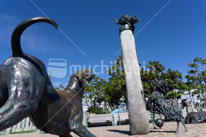 Hairy Maclary characters Scarface Claw on top of pole and Blitzer Maloney and  Muffin McLay statues in bronze on Tauranga waterfront, New Zealand