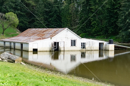 Flooded farm building surrounded with water following the rain.