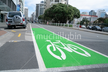 WELLINGTO, NEW ZEALAND - OCTOBER 1 2018; White graphic of cycle on green background marking street cycle lane on city street.
