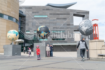 WELLINGTON, NEW ZEALAND - OCTOBER 1 2018; TChildren and tourists around Other Worlds sculpture by Ruth Watson installed in 2018 on Wellington waterfront with architectural features of Te Papa, New Zealand Museum behind.