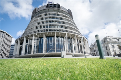 New Zealand Government buildings the Beehive beyond green lawn.