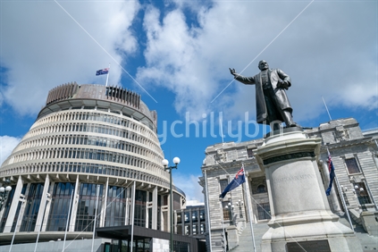 New Zealand Government buildings, House neo classical style House of Parliament with Beehive behind.statue Richard John Seddon pionting forwards.
