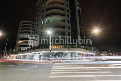 MOUNT MAUNGANUI NEW ZEALAND - FEBRUARY 7 2019: Pedestrian Crossing Apartments and cafes Marine Parade corner at base of mount street illuminated by street lights