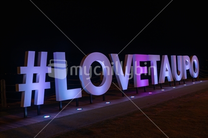 Love Taupo bright white tourism promotional sign at night