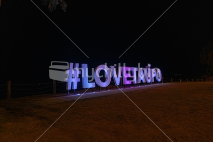 Love Taupo bright white tourism promotional sign at night