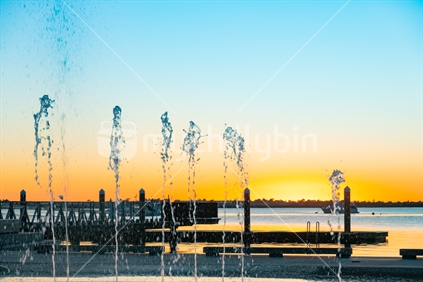 Tauranga waterfront water feature as sunrises across harbour.