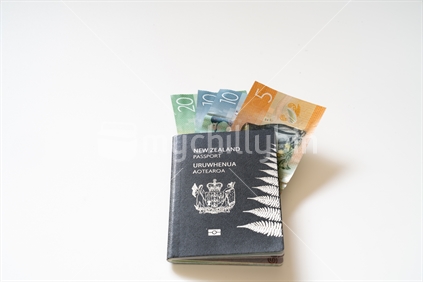 New Zealand passport and currency on white background.