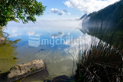 Scenic lake landscape as mist rises over Lake Okareka New Zealand.