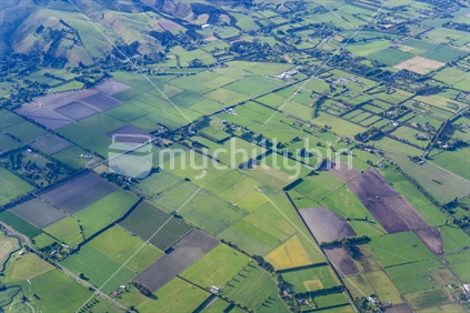 Patterned rural landscape below with shadows from clouds.