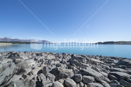 Lake Pukaki bright blue with distant Souther Alps and Mount Cook in Canterbury, New Zealand