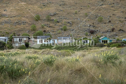 Christchurch New Zealand - November 21 2020; Typical iconic holiday home baches on beach at Taylors Mistake bay