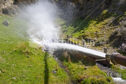 Cromwell New Zealand - November 10 2020; Water jet for sluicing under old hut on side of hill at site of old historic gold mining village in Kawarau Gorge.