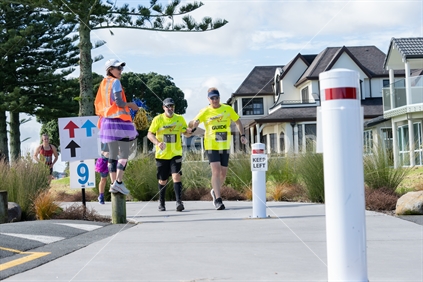 Tauranga New Zealand - April 2 2023; Disabled participater and helper in  Pay What You Want (PWYW) marathon on streets and though parks of harbourside suburbs