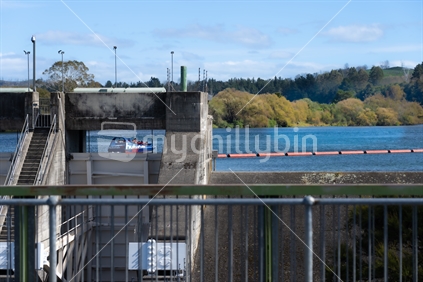 Taupo New Zealand - April 15 2023; Huka Falls tourist jetboat on Waikato river behind dam at Aratitia