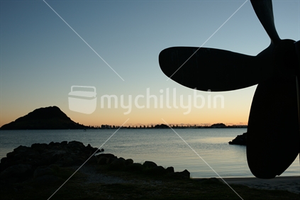 Backlit, Mount Maunganui and ships propeller on Sulphur Point Tauranga, just before sunrise, New Zealand