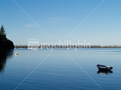 Blue shades, the calm water of Tauranga habour wi th dinghy.