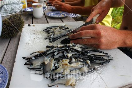Paua being sliced in preparation for cooking.