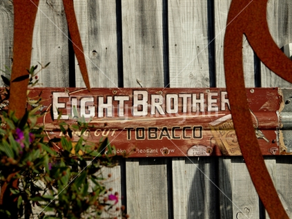 Eight Brothers very old tobacco sign on a rural fence in New Zealand; soon to be a thing of the past.