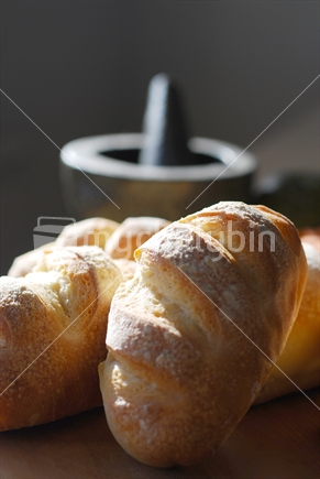 Bread rolls with mortar and pestle in the background