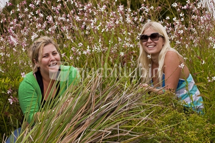 2 girls sitting amongst the flowers