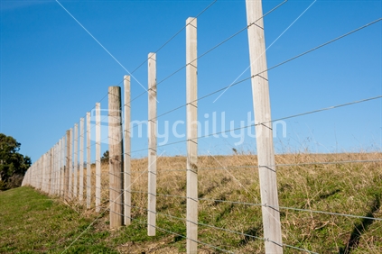 Close up of a typical farm fence, with blue sky