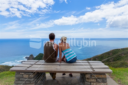 Couple looking out to the ocean at Cape Reinga, North Island, New Zealand