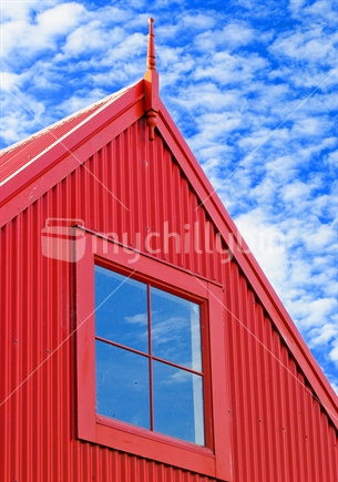 Red shed with blue sky and white clouds