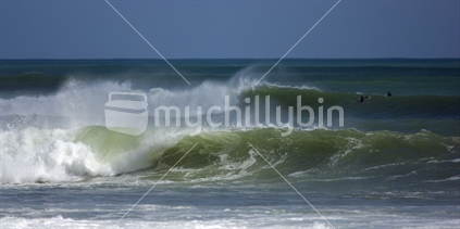 Image of breaking waves with two guys out surfing, Raglan, New Zealand