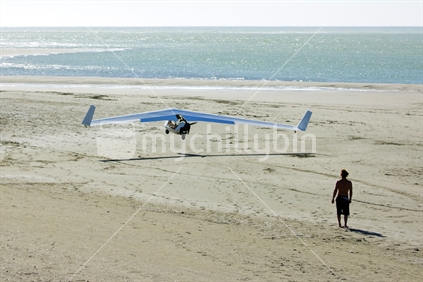Person taking off their plane from the sand by the ocean