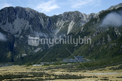 Mt Cook Village and The Hermitage nestled in against steep rugged hills of the Southern Alps.  Tasman Valley, South Canterbury.