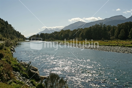 Ripples on the Jackson River, with mountains in the background, South Westland, South Island.