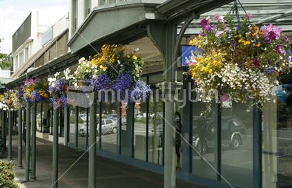 Iconic hanging baskets of bright cheerful coloured flowers along the footpath of Gore main street.