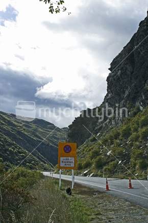 Warning sign and roadblock, while Nevis Bluff is blasted to remove loose rocks for safety.  Central Otago.