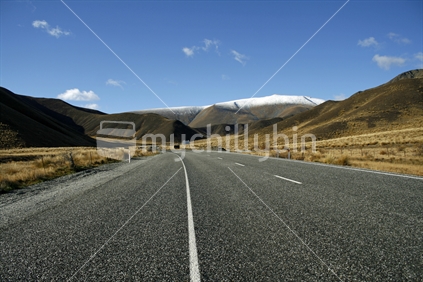 Line of the roadside leading to rolling hills in Lindis Pass.