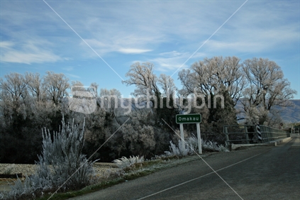 Beautiful hoar frosted trees by the bridge leading to Omakau, Central Otago, New Zealand.